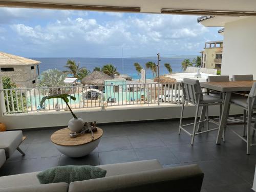 a living room with a view of the ocean from a balcony at Grand Windsock Bonaire in Kralendijk