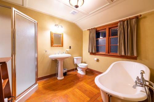 a bathroom with a sink and a tub and a toilet at Johnston Canyon Lodge & Bungalows in Castle Junction