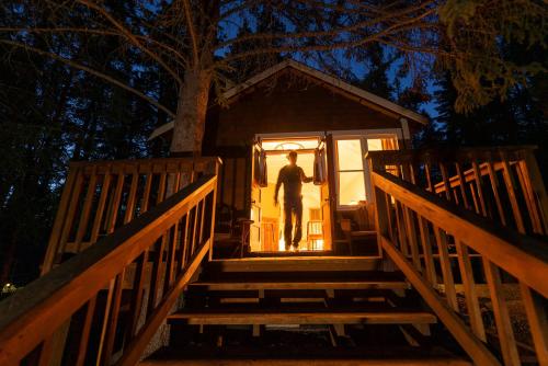a man standing on the stairs of a tiny house at Johnston Canyon Lodge & Bungalows in Castle Junction