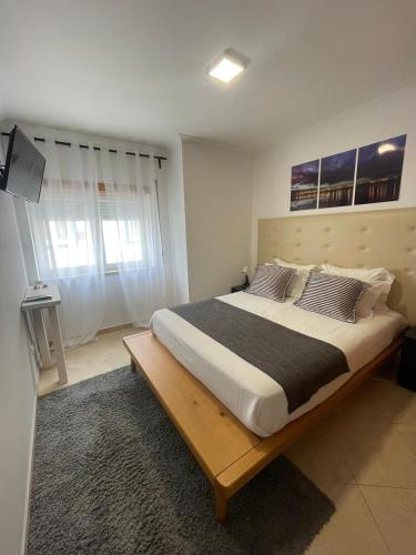 1 dormitorio con 1 cama grande con marco de madera en Cricket Apartments, en Ferrel