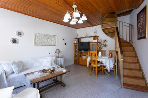 a living room with a white couch and a table at Nature Village Apartment in Áyioi Dhéka