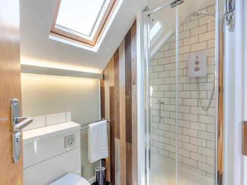 a bathroom with a toilet and a shower with a skylight at Beach Haven - Uk42241 in Littlestone-on-Sea