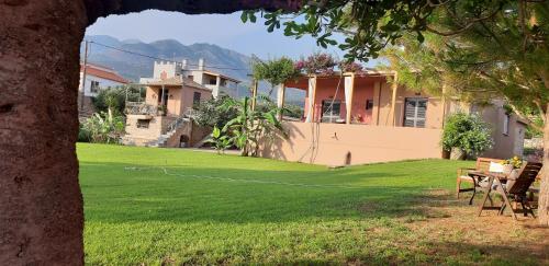 a yard with a tennis court in front of a house at Malsova-Home in Kotrónion