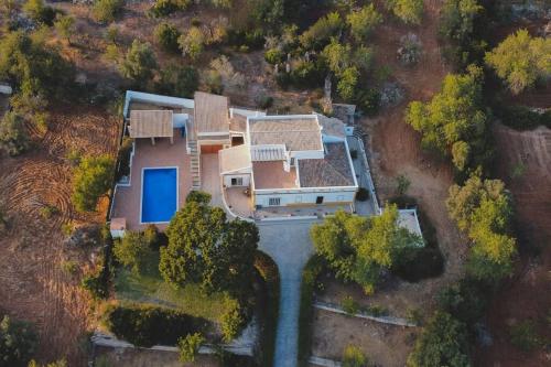 an aerial view of a house with a blue pool at Casa das Palmeiras - Villa com piscina, BBQ e ar condicionado in Albufeira