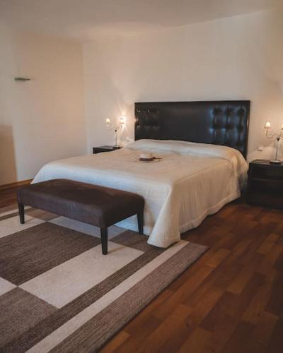 a bedroom with a large bed with a black headboard at Casa das Palmeiras - Villa com piscina, BBQ e ar condicionado in Albufeira