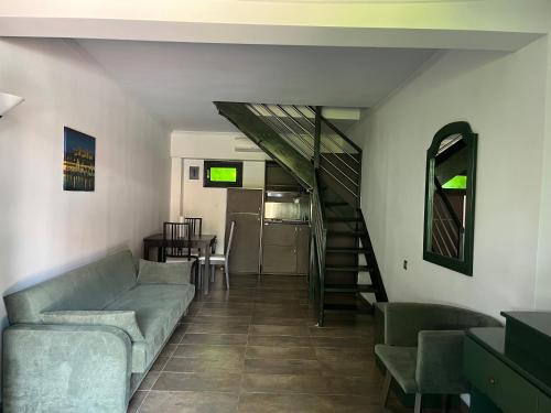 a living room with a couch and a staircase at Eden Hotel in Afitos