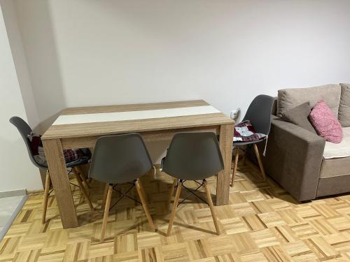 mesa de comedor con 4 sillas y sofá en Welcoming Apartment w/ Wi-Fi + Private Bathroom, en Struga