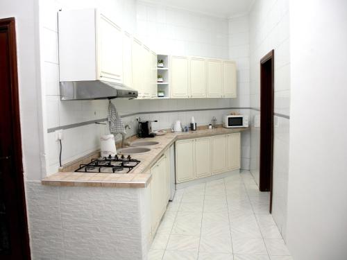 eine weiße Küche mit einer Spüle und einem Herd in der Unterkunft Malì Casa Vacanze in Neapel