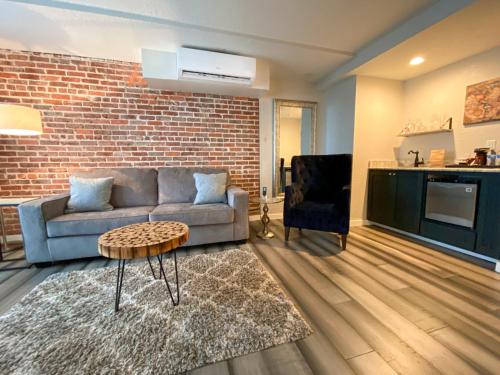 a living room with a couch and a brick wall at Artisan Downtown in DeLand