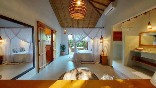 a room with a bedroom with a bed and a window at Vila dos Macacos Trancoso in Trancoso