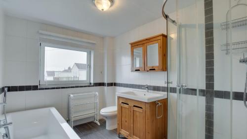 a bathroom with a toilet and a sink and a shower at Woodville Road, Mumbles in The Mumbles