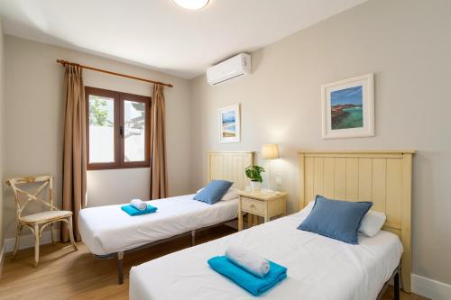 a bedroom with two beds and a window at Villa Caleta Heights by Villa Plus in Caleta De Fuste