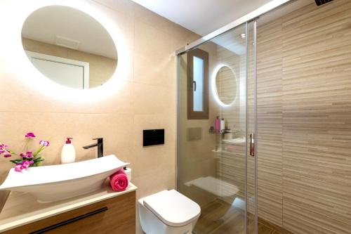 uma casa de banho com um WC, um lavatório e um espelho. em Villa Caleta Heights by Villa Plus em Caleta de Fuste