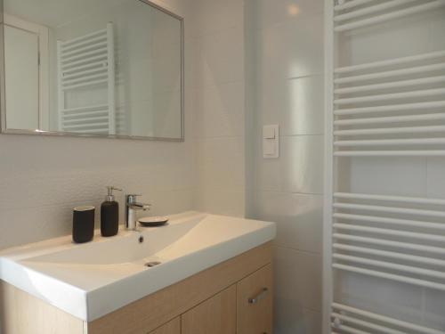 a bathroom with a white sink and a mirror at Katia's sunny penthouse apartment in Piraeus