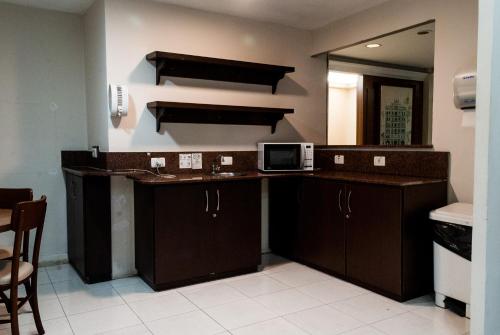 uma cozinha com um lavatório e um micro-ondas em Master Grande Hotel - Centro Histórico em Porto Alegre