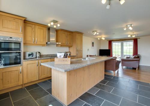 a large kitchen with wooden cabinets and a counter top at Llys Bach in Llanarmon