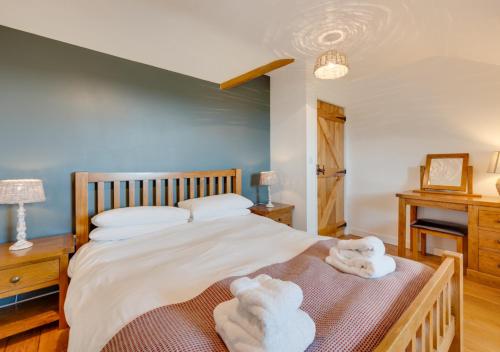 a bedroom with a large bed with towels on it at Llys Bach in Llanarmon