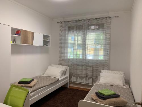 a small room with two beds and a window at Bonaca in Izola