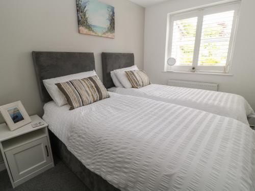 a bedroom with two beds and a window at 1 Old Farm Court in Barnstaple