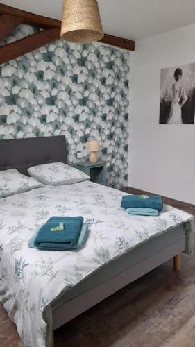 une chambre avec un lit avec des serviettes bleues dessus dans l'établissement les galipes, à Hautvillers