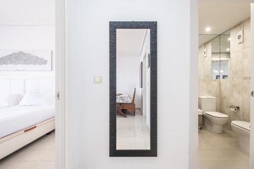 ベニドルムにあるGemelos 26 Resort Apartment 27C Levante Beachのベッドルーム(鏡、ベッド1台、バスルーム付)