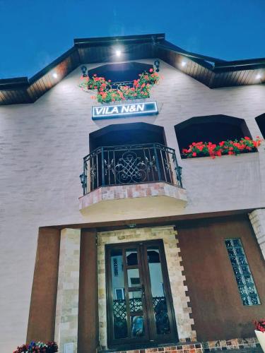 a building with a balcony with flowers on it at Vila N&N Palace in Bistriţa Bîrgăului
