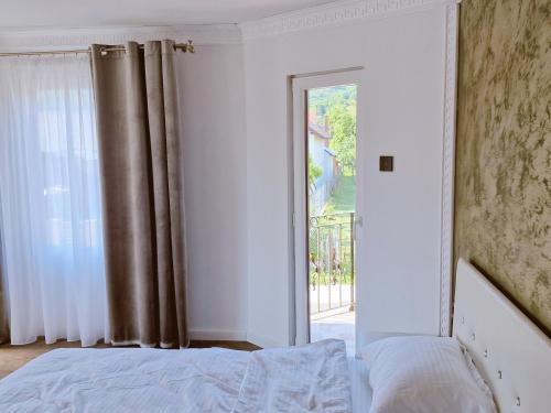 a bedroom with a bed and a sliding glass door at Vila N&N Palace in Bistriţa Bîrgăului