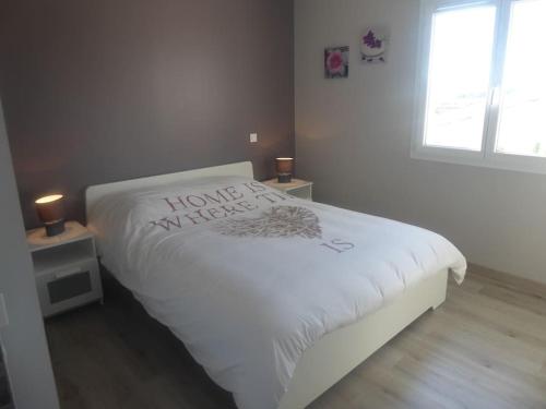 a bedroom with a white bed with a home madeigil at la Luna in Lapalme