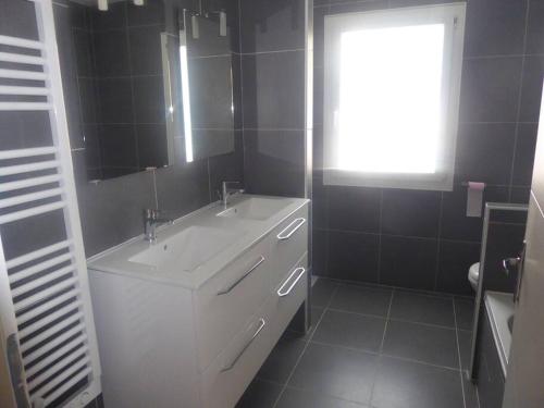 W łazience znajduje się biała umywalka i lustro. w obiekcie la Luna w mieście Lapalme
