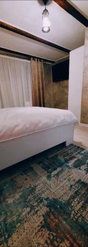 a bedroom with a bed with a rug and a curtain at Vila N&N Palace in Bistriţa Bîrgăului