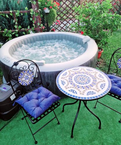 a hot tub with a table and chairs in front of it at Vila N&N Palace in Bistriţa Bîrgăului