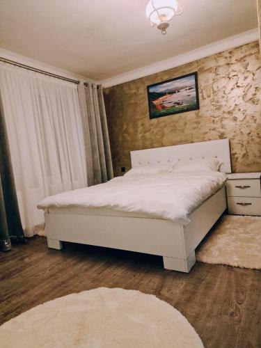 a bedroom with a white bed in a room at Vila N&N Palace in Bistriţa Bîrgăului