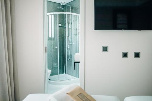 uma casa de banho com um chuveiro e uma porta de vidro em Next Level Premium Hotels em Lisboa
