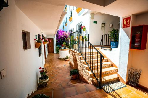 un couloir avec des escaliers et des plantes en pot dans un bâtiment dans l'établissement Marbella Village, à Marbella