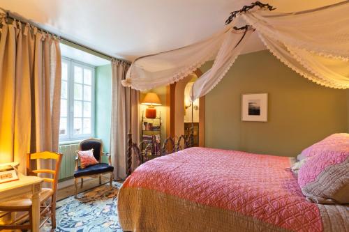 um quarto com uma cama de dossel em A l'Ombre du Château em Nans-sous-Sainte-Anne