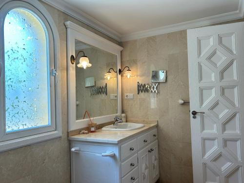 ein Badezimmer mit Waschbecken und Spiegel in der Unterkunft Villa close to the beach in Marbella in Marbella
