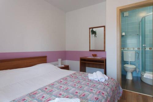 sypialnia z łóżkiem i łazienką z toaletą w obiekcie Komforan apartman 2+2 w Hvarze