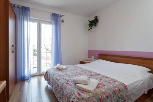 sypialnia z łóżkiem i dwoma ręcznikami na nim w obiekcie Komforan apartman 2+2 w Hvarze