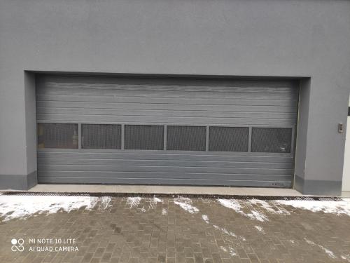 a metal garage door on a building at Apartament Pileckiego Nowy Dwór Mazowiecki Airport Modlin 24 H in Nowy Dwór Mazowiecki