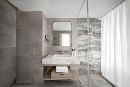 a bathroom with a sink and a mirror at voco Ma Belle Danang by IHG in Da Nang