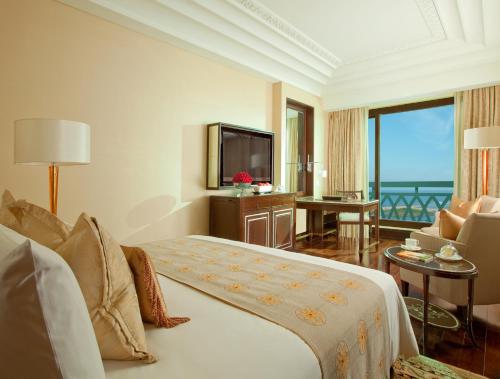 a hotel room with a bed and a television at The Leela Palace Chennai in Chennai