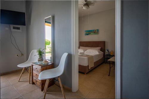 a bedroom with a bed and a table and two chairs at Olivemare Holidays in Nea Irakleia