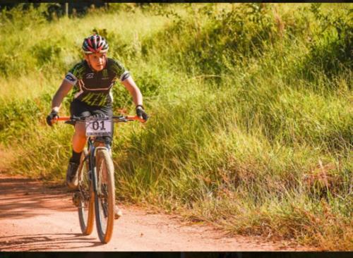 a man riding a bike down a dirt road at Pousada Filhos da Canastra in Vargem Bonita