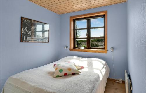 a bedroom with a bed with two pillows and a window at Amazing Home In Glesborg With 5 Bedrooms, Sauna And Wifi in Tvedhuse