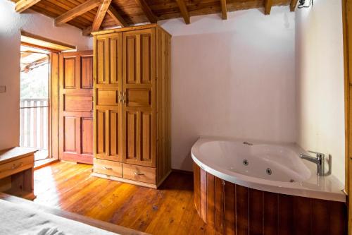 a bathroom with a tub and a wooden floor at Havuzu korunaklı 2+1 taş villa in Kınalı