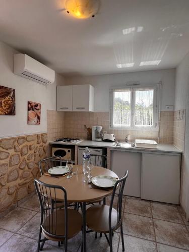 uma cozinha com uma mesa e cadeiras numa cozinha em Orizzonte montagna em Figari