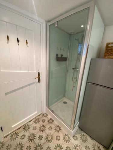 una ducha con puerta de cristal en un baño en Beach Bliss, en Noordwijk