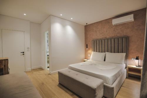 a bedroom with a large bed and a ottoman in it at Luxury Villa Alisja Sarande with Private Beach in Sarandë
