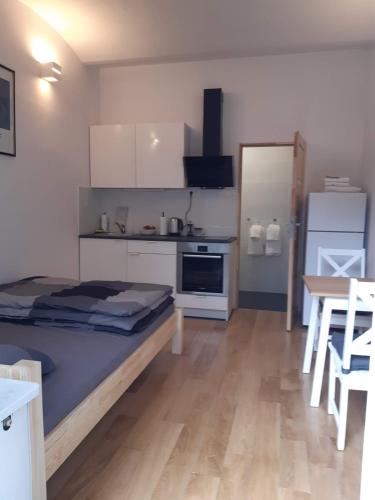 a room with a bed and a kitchen with a table at Apartament Klimt 1 in Bielsko-Biała