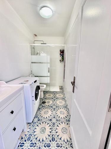 a bathroom with a washing machine and a tile floor at Alma 26 in Los Cancajos